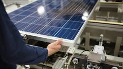 A production line worker helps assemble solar panels. A production line worker helps assemble solar panels.